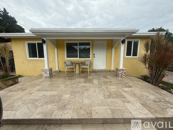 A yellow house with a patio and a table set up for two.