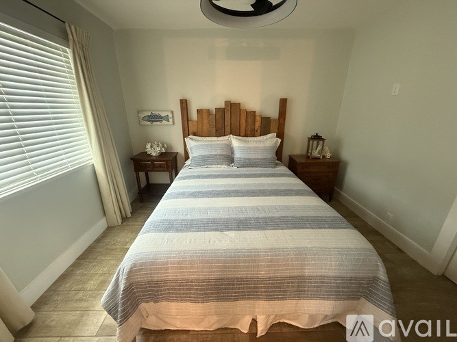 A bedroom with a large bed and a ceiling fan.