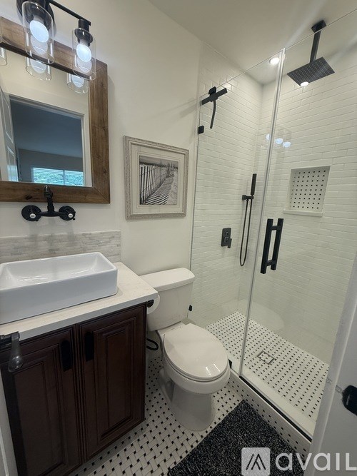 A bathroom with a toilet, sink, and shower.
