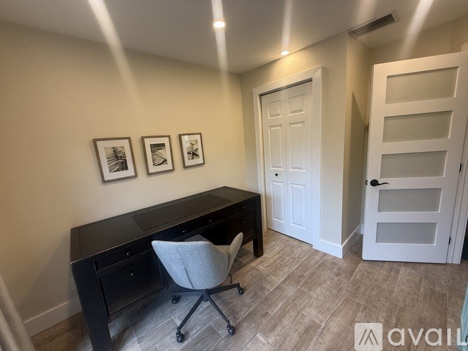 A room with a black desk and a white chair.