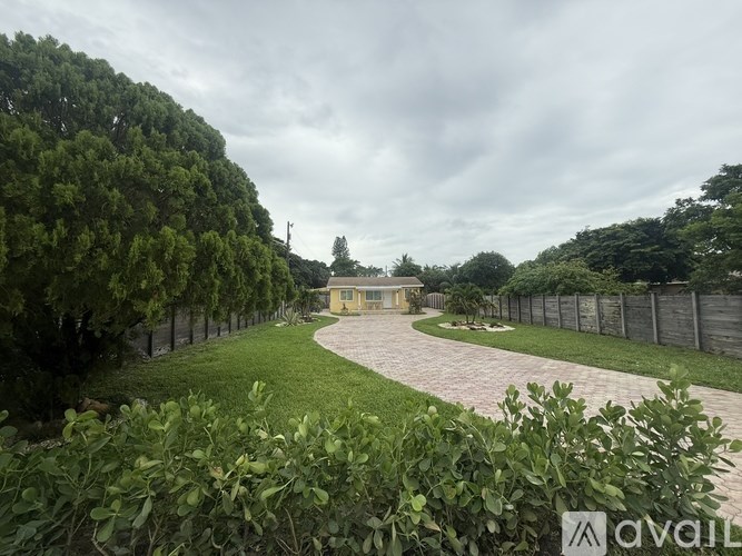 A house is surrounded by a fence and greenery.