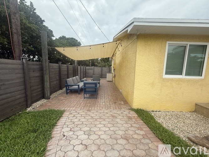 A yellow house with a patio and a fence.