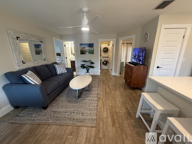 A living room with a blue couch and a white ceiling fan.