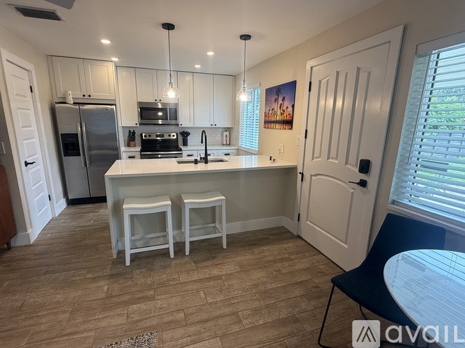 A kitchen with a refrigerator, stove, and sink.