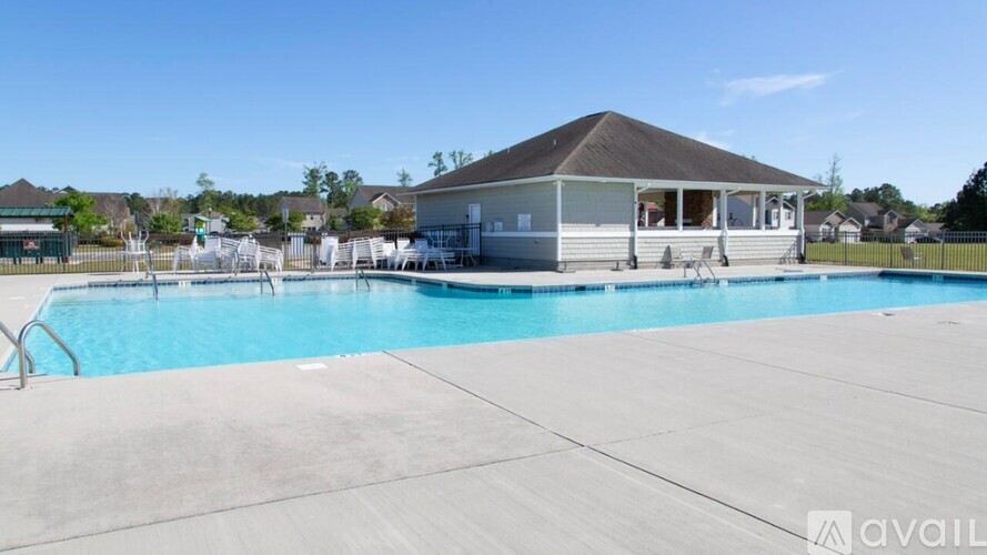 A pool with a house in the background.