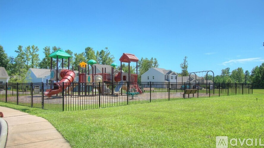 A playground with a red slide and green canopies.