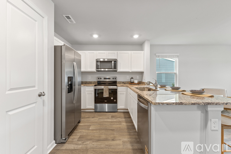 A kitchen with a stainless steel refrigerator and white cabinets.