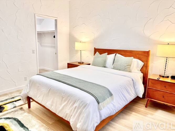 A bedroom with a bed, nightstand, and lamp.