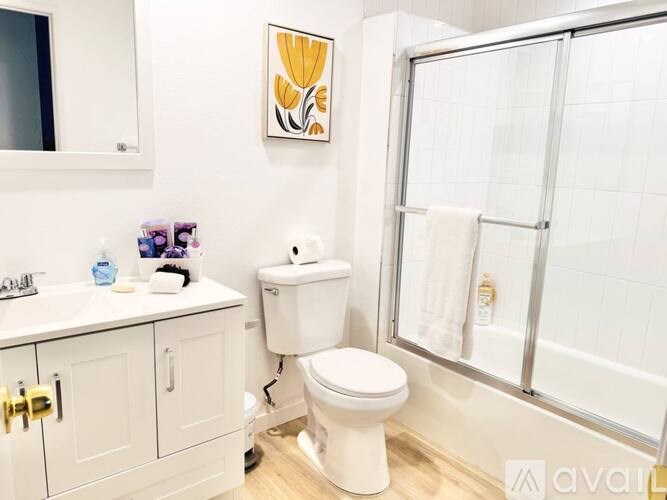 A white toilet sits in a bathroom next to a sink and a window.