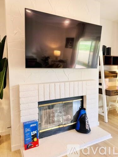A flat screen TV mounted above a fireplace in a living room.