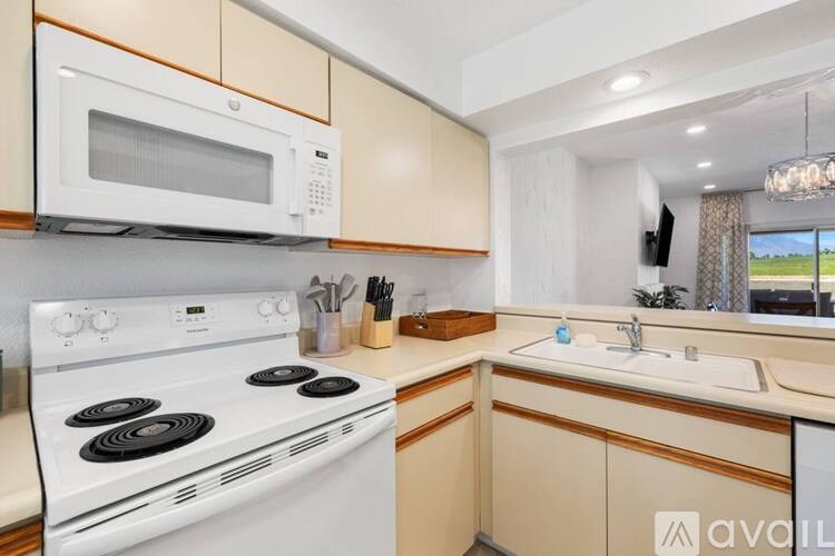 A kitchen with a white stove and a white microwave above it.