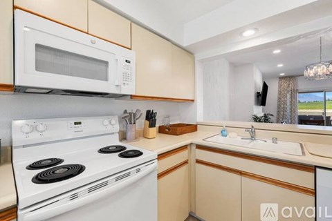A kitchen with a white stove and a white microwave above it.