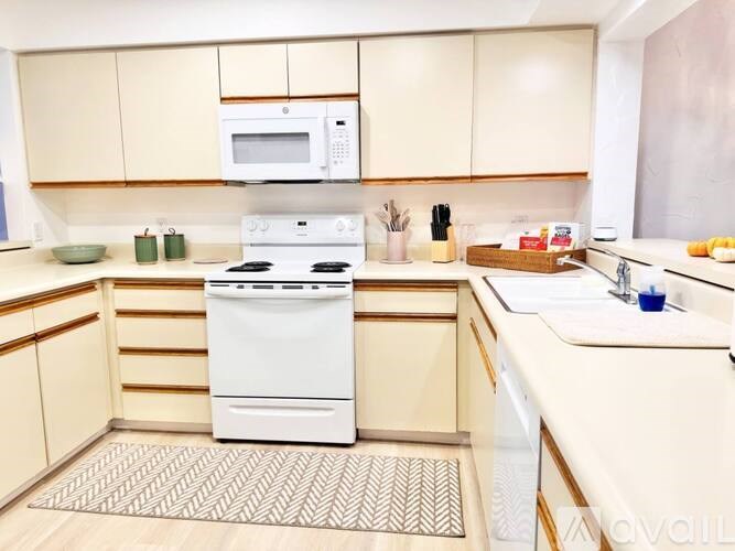 A white stove and microwave in a kitchen with wooden cabinets.