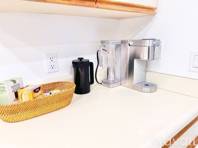 A kitchen counter with a basket of items and a coffee maker.