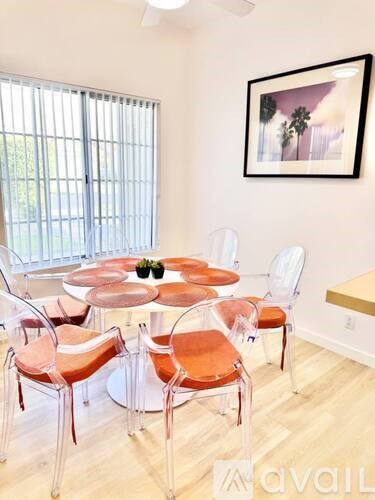 A dining room with a round table and chairs.