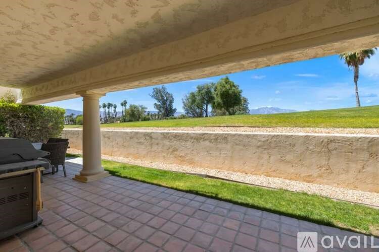 A patio with a table and chairs under a roof.