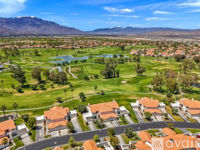 A bird's eye view of a residential area with houses and a golf course.