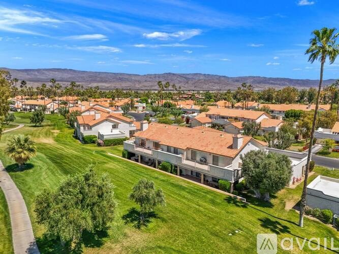 A bird's eye view of a neighborhood with houses and palm trees.