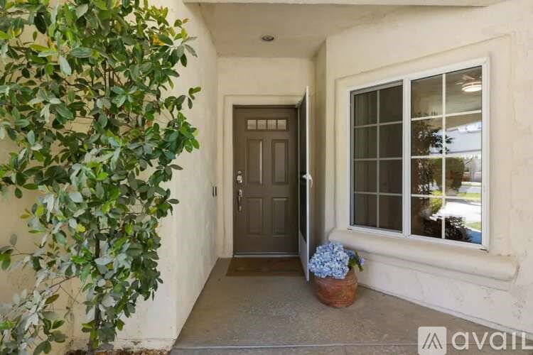 A door is in a white wall with a window to the right.
