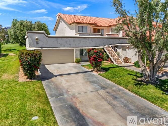 A modern house with a red tile roof and a concrete driveway.