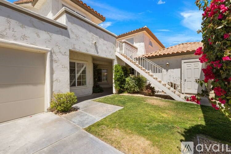 A house with a garage and a staircase leading to a balcony.