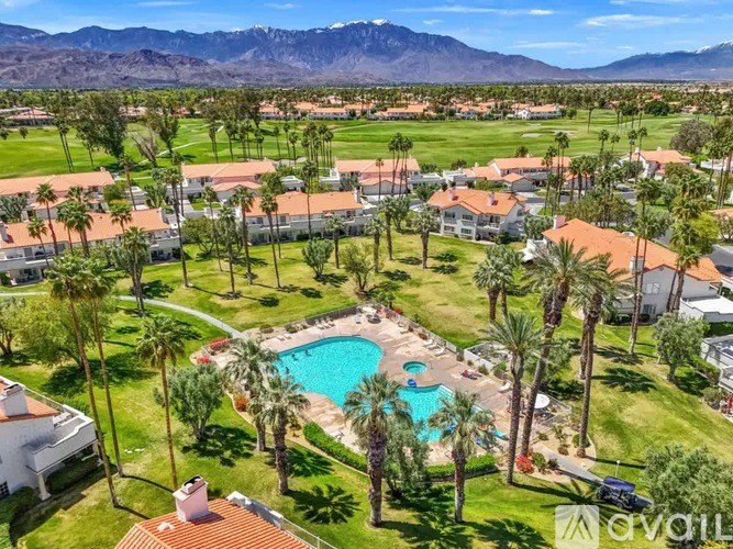 A bird's eye view of a community with a pool and palm trees.
