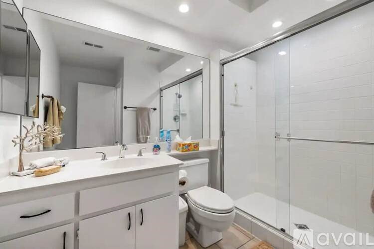 A white bathroom with a toilet, sink, and mirror.