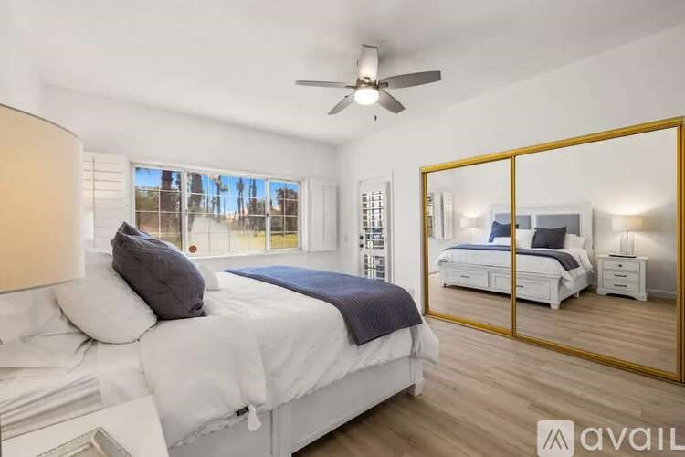 A bedroom with a large bed and a ceiling fan.
