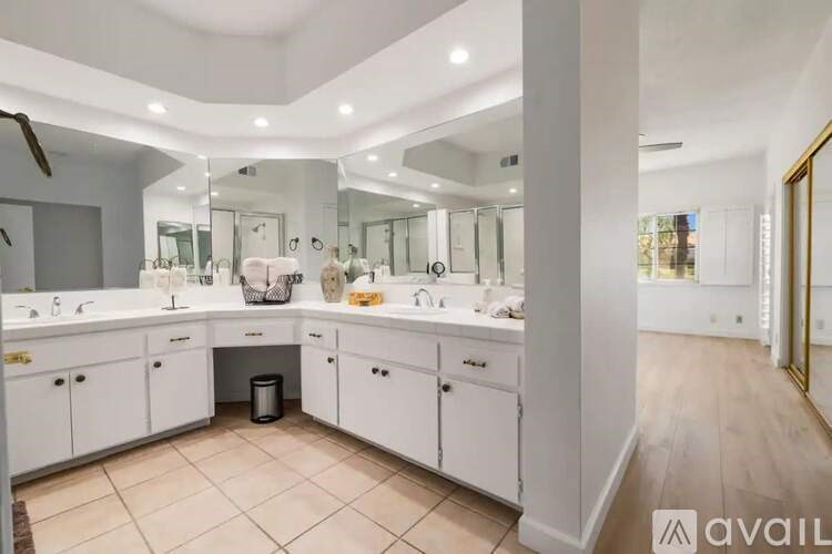 A bathroom with two sinks and a large mirror.