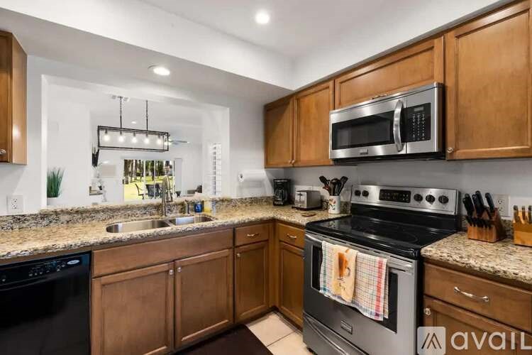 A kitchen with wooden cabinets and a black dishwasher.
