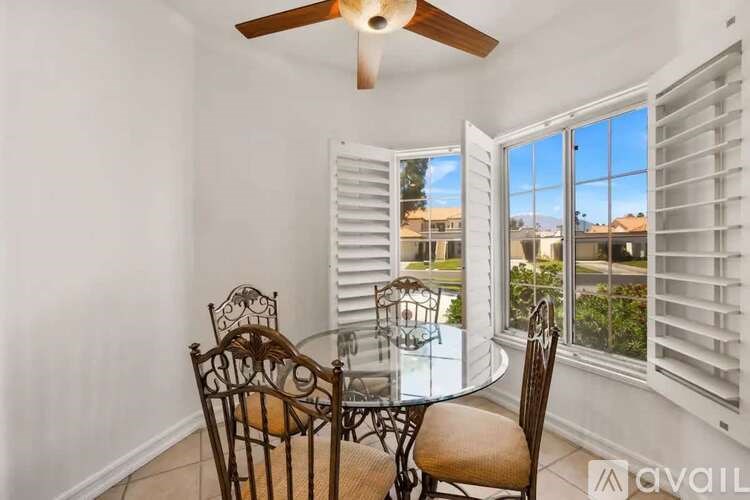 A dining room with a glass table and chairs.