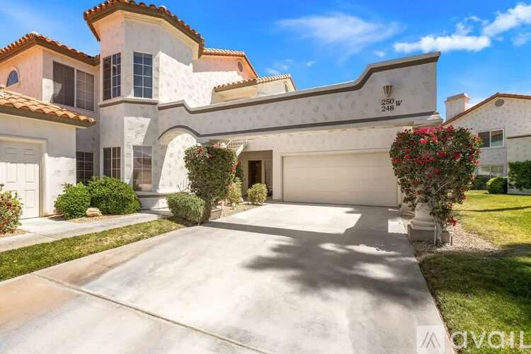 A large house with a driveway in front.