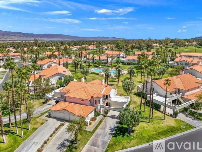 A bird's eye view of a residential area with houses and palm trees.