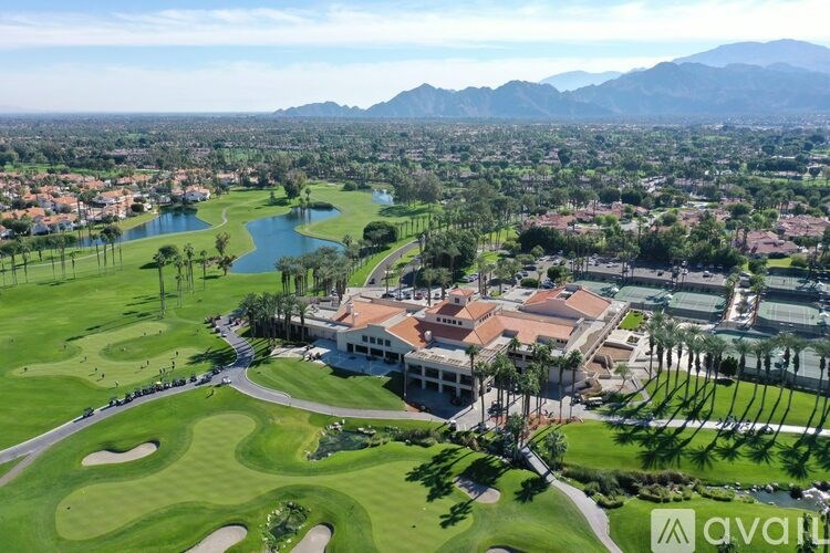 A golf course with a clubhouse and palm trees.