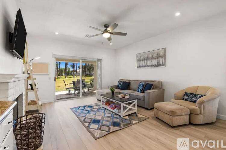 A living room with a television, a couch, and a chair.
