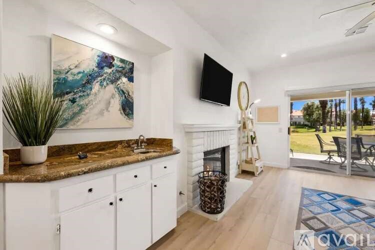 A modern kitchen with a marble countertop and white cabinets.
