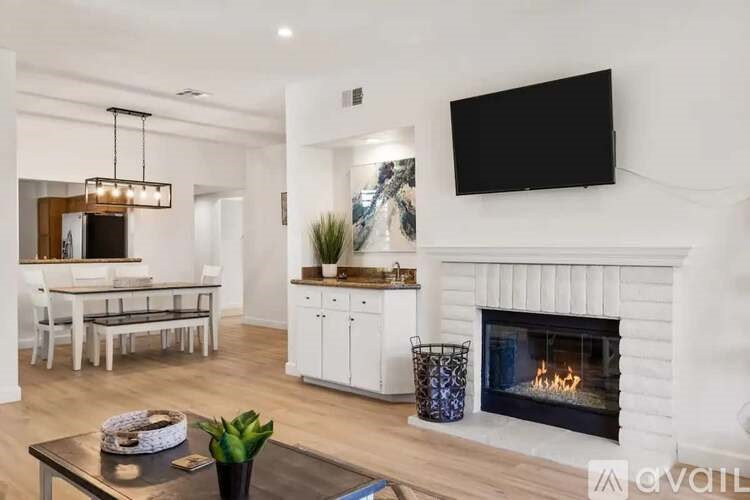 A modern living room with a fireplace and a flat screen TV mounted on the wall.