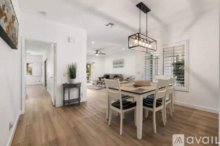 A modern dining room with a wooden table and chairs.