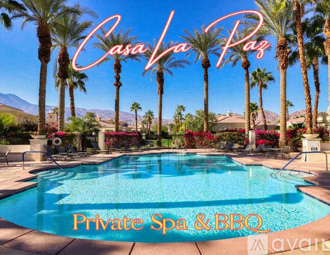 A pool surrounded by palm trees and the words "Casa Vina Paz" written in the sky.