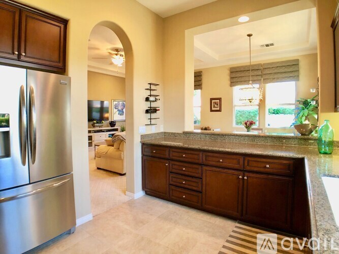 A kitchen with a refrigerator, sink, and cabinets.