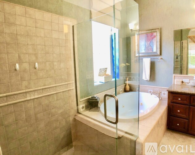A bathroom with a glass shower door and a bathtub.