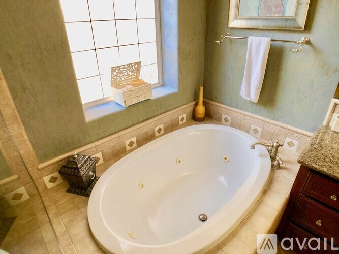 A bathroom with a tub and a window.