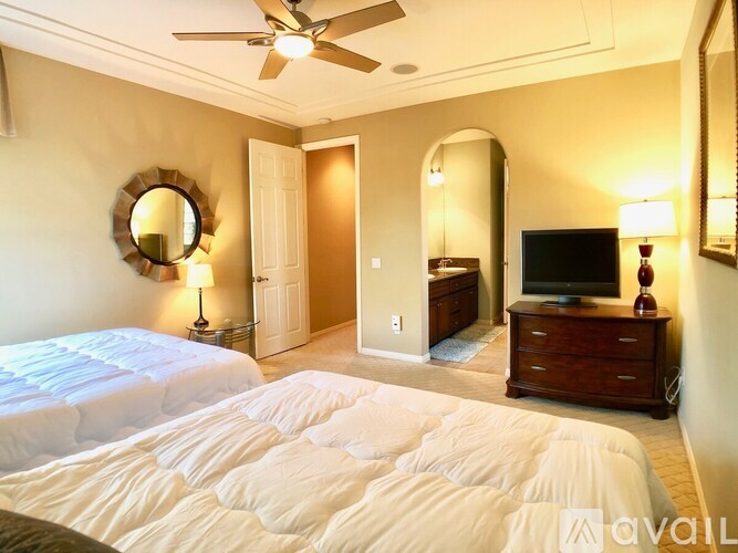 A bedroom with a large bed and a ceiling fan.