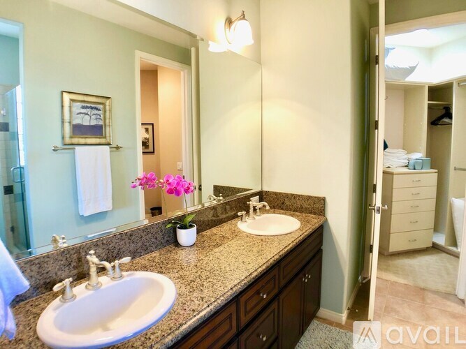 A bathroom with two sinks and a large mirror.