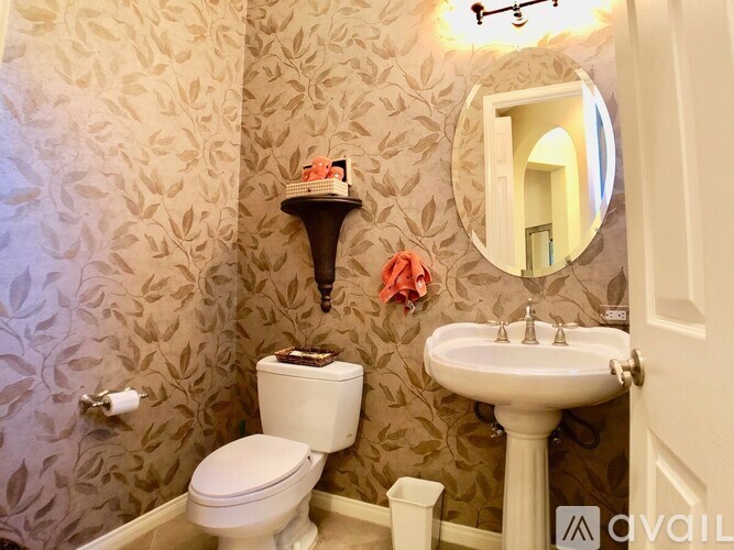 A bathroom with a toilet, sink, and a mirror.