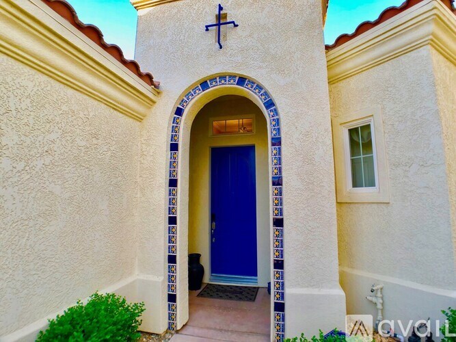 A house with a blue door and a cross above it.