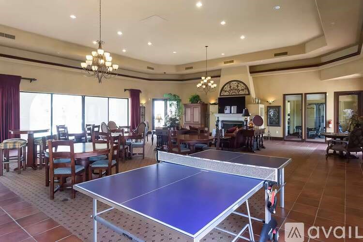 A ping pong table is in the middle of a room with a lot of furniture.