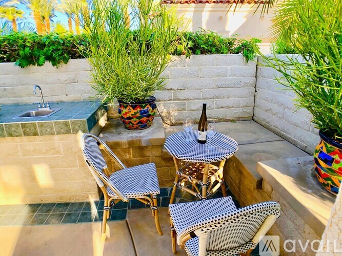 A patio with a table and chairs and a potted plant.