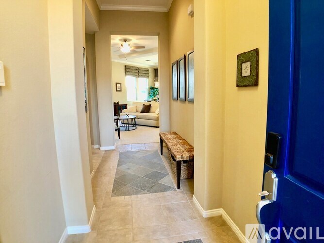 A hallway with a bench and pictures on the wall.