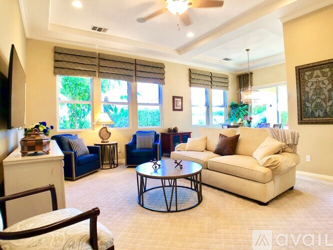 A living room with a blue couch, a white couch, and a coffee table.